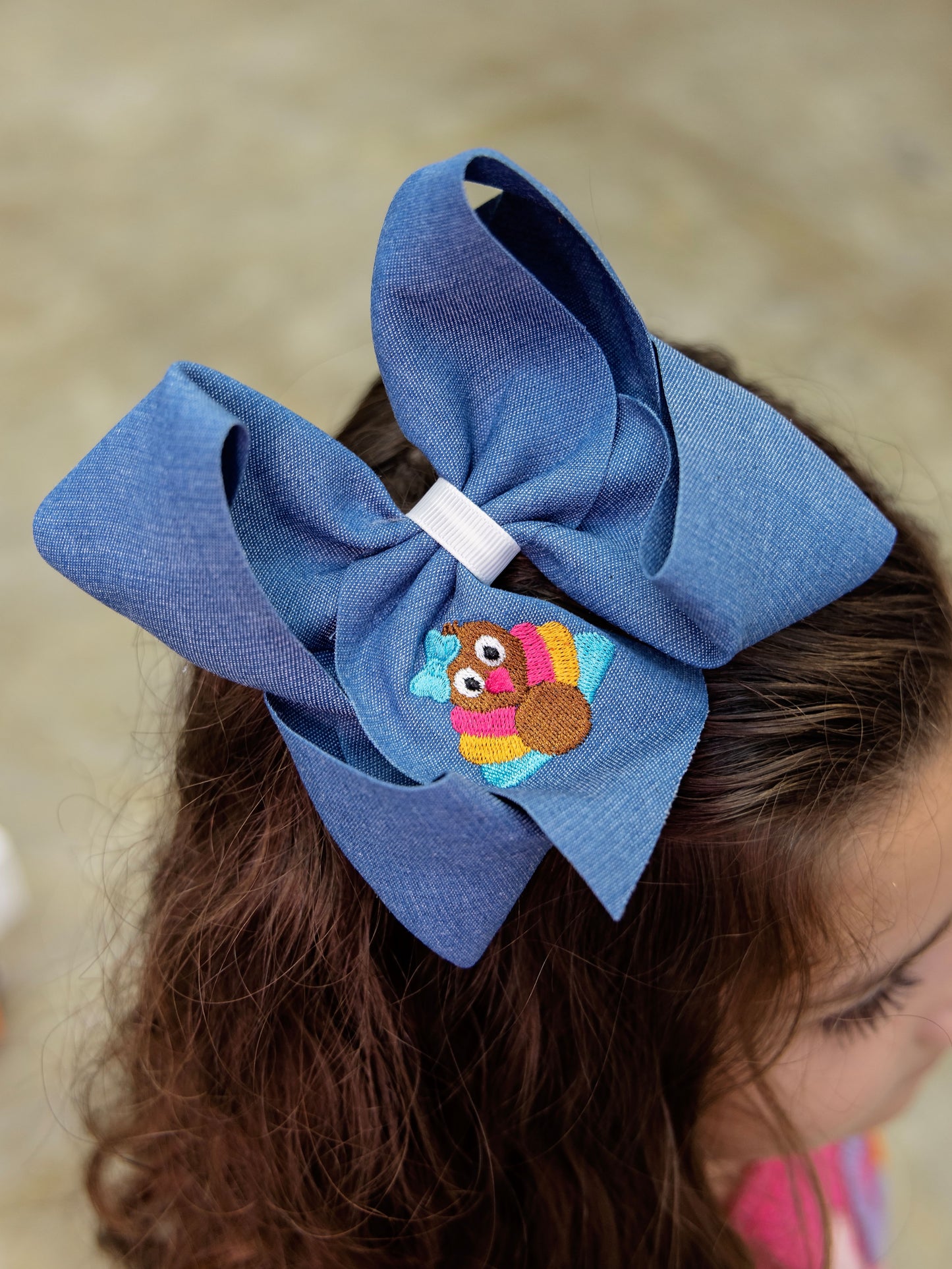 Model wearing the Pink Turkey Embroidery on Denim Hair Bow