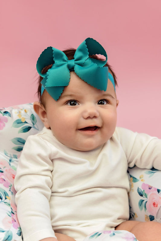 Baby wearing a teal 4.5 inch classic scalloped hair bow on a satin headband - Alternative view