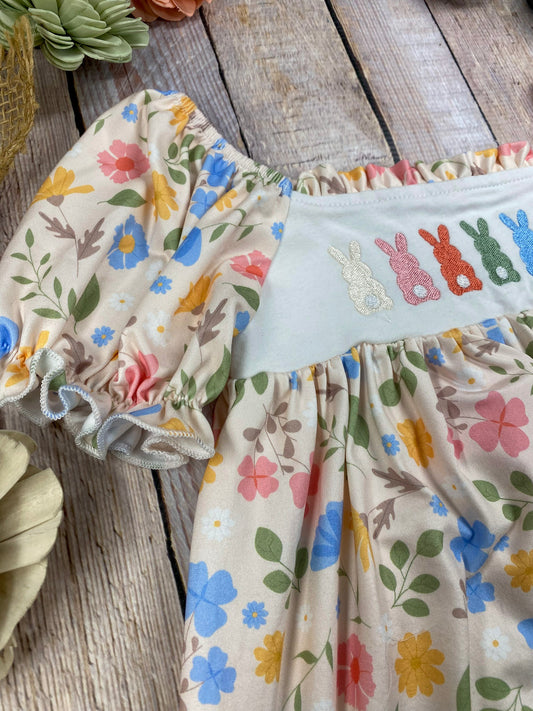 zoom in on Children's outfit with floral top and bunny print pants on a wooden surface - Alternative view