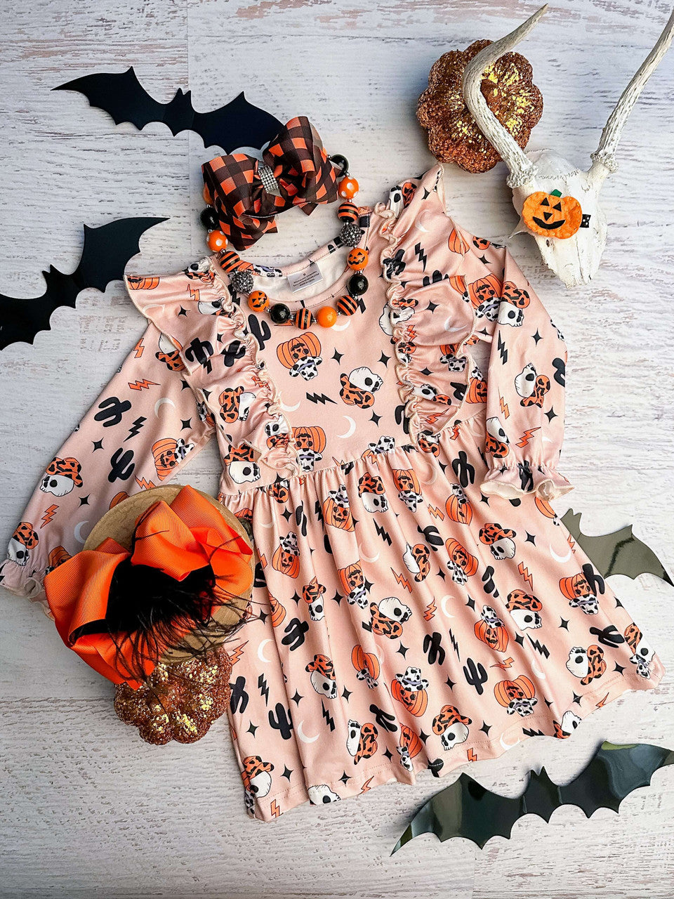 light orange ruffled dress with cowboy jack-o-lanterns and skeletons