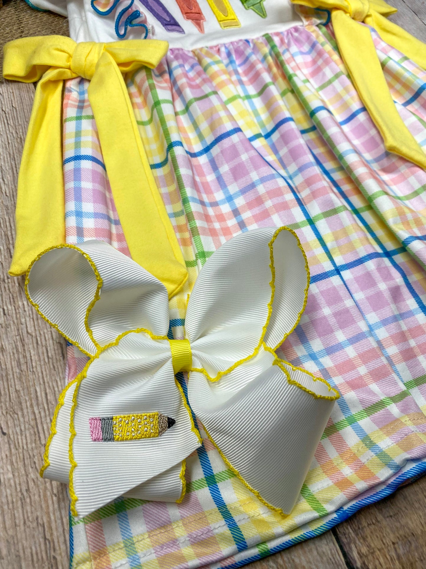 Girls back to school boutique dress with crayon appliqué, rainbow plaid ruffle sleeves, yellow bow ties, and plaid skirt