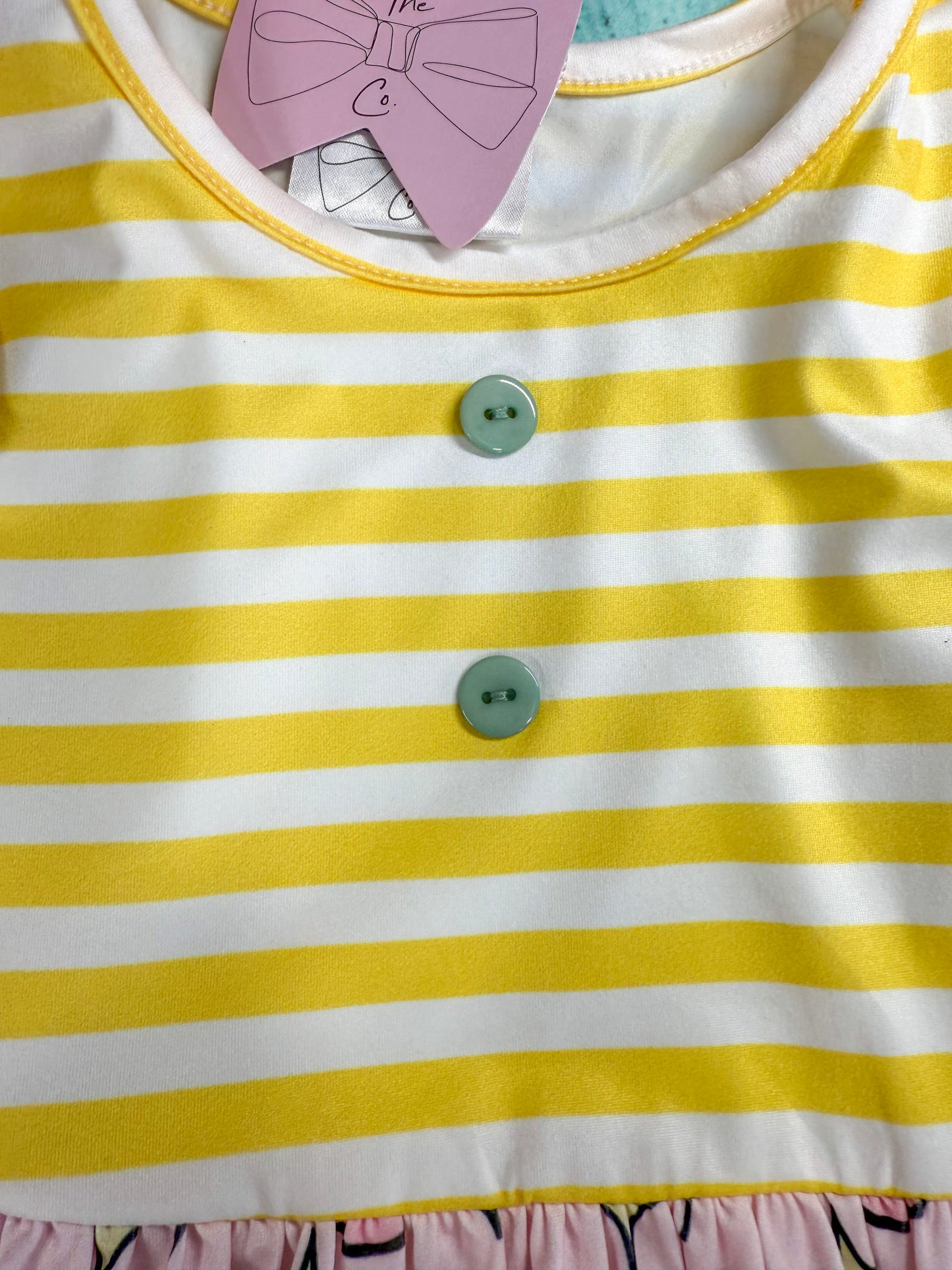 close up photo showing the buttons and yellow stripes on top of the dress