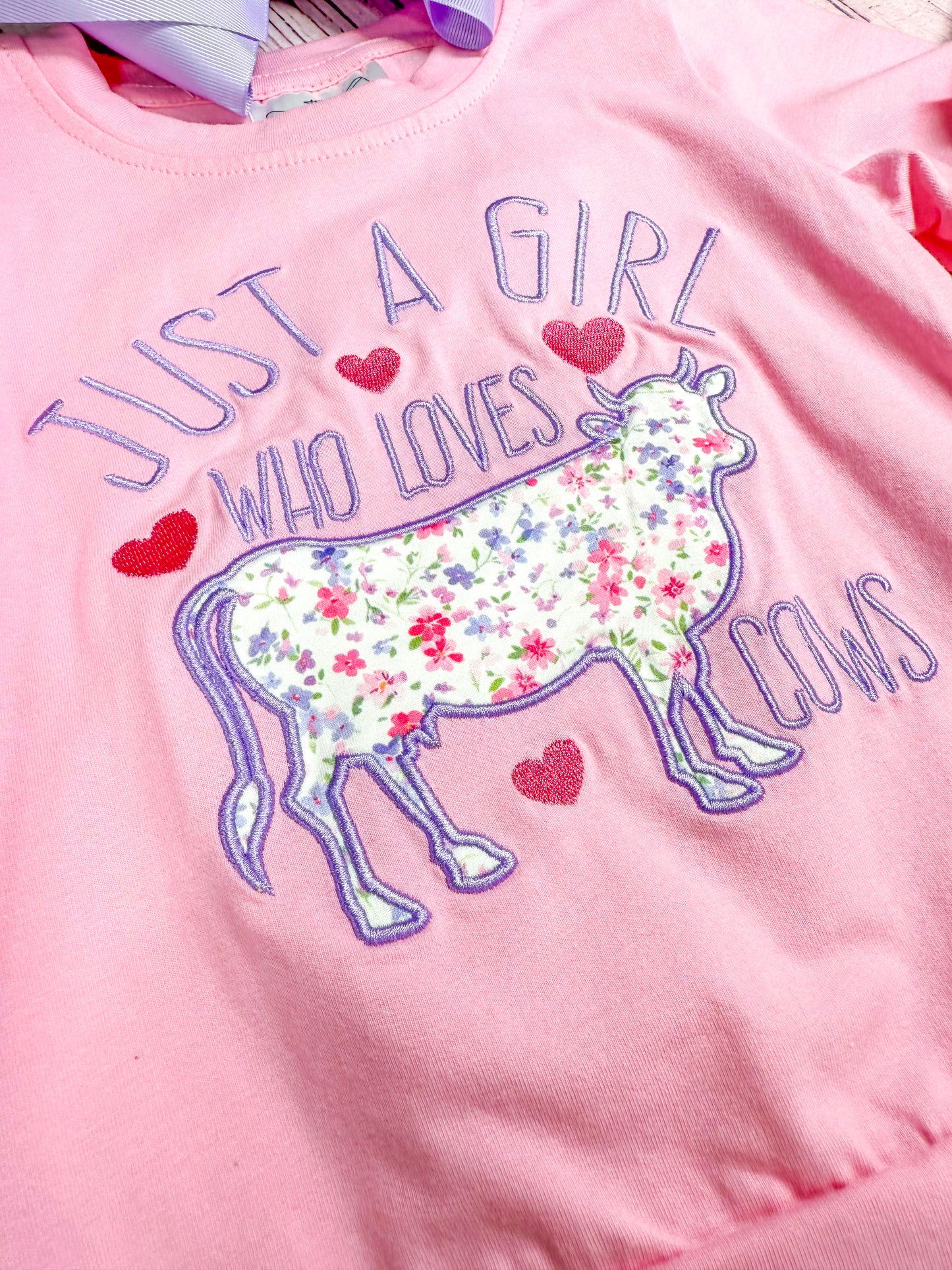 close up of "just a girl who loves cows" with cow embroidery