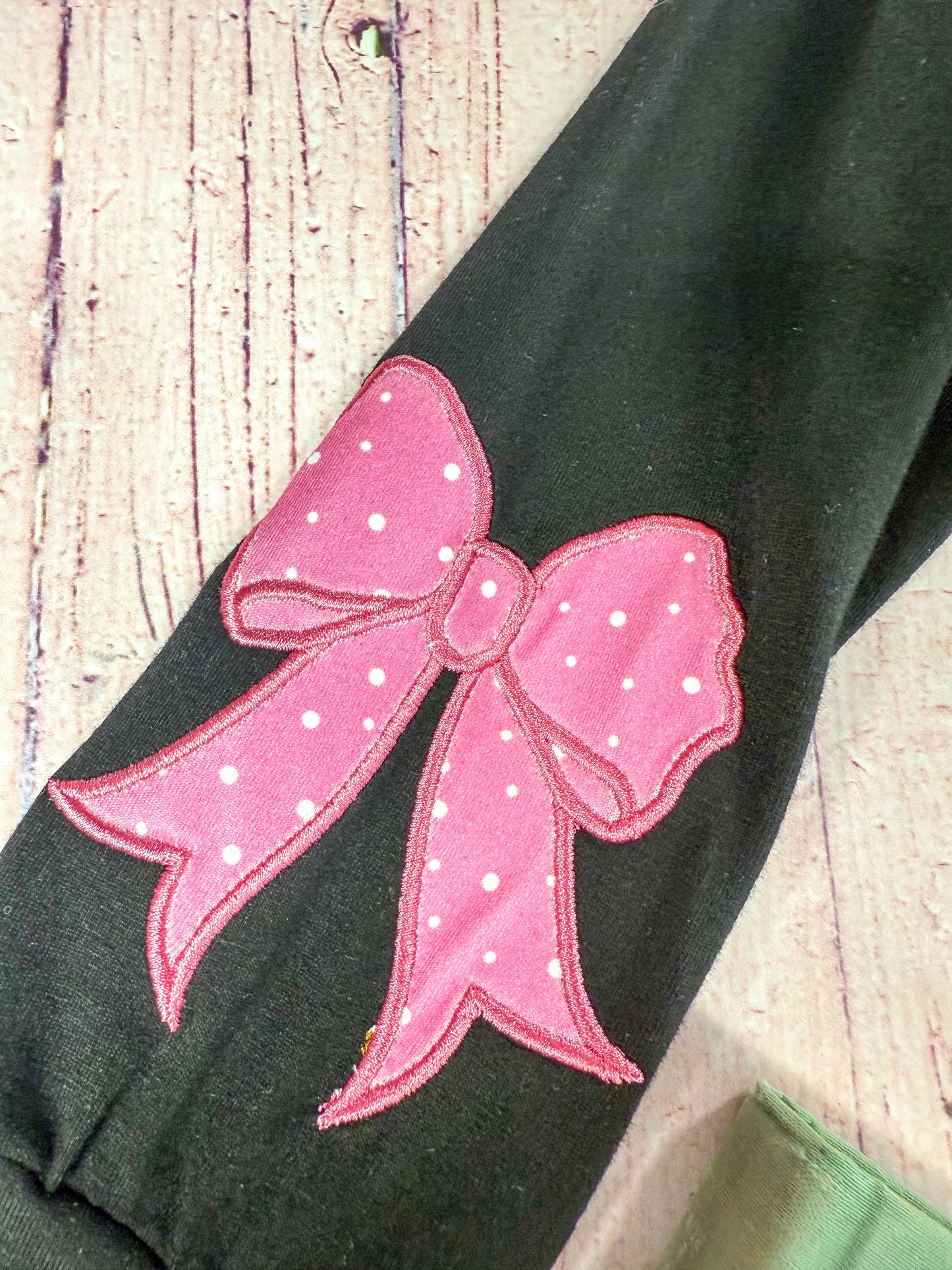 close up of the bow embroidery on sleeve of top