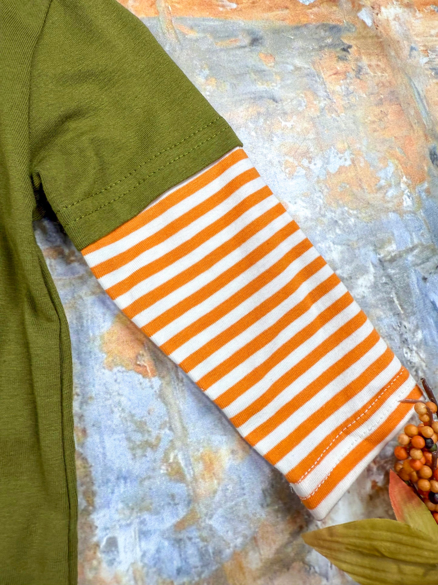 close up of the orange and white striped long sleeve