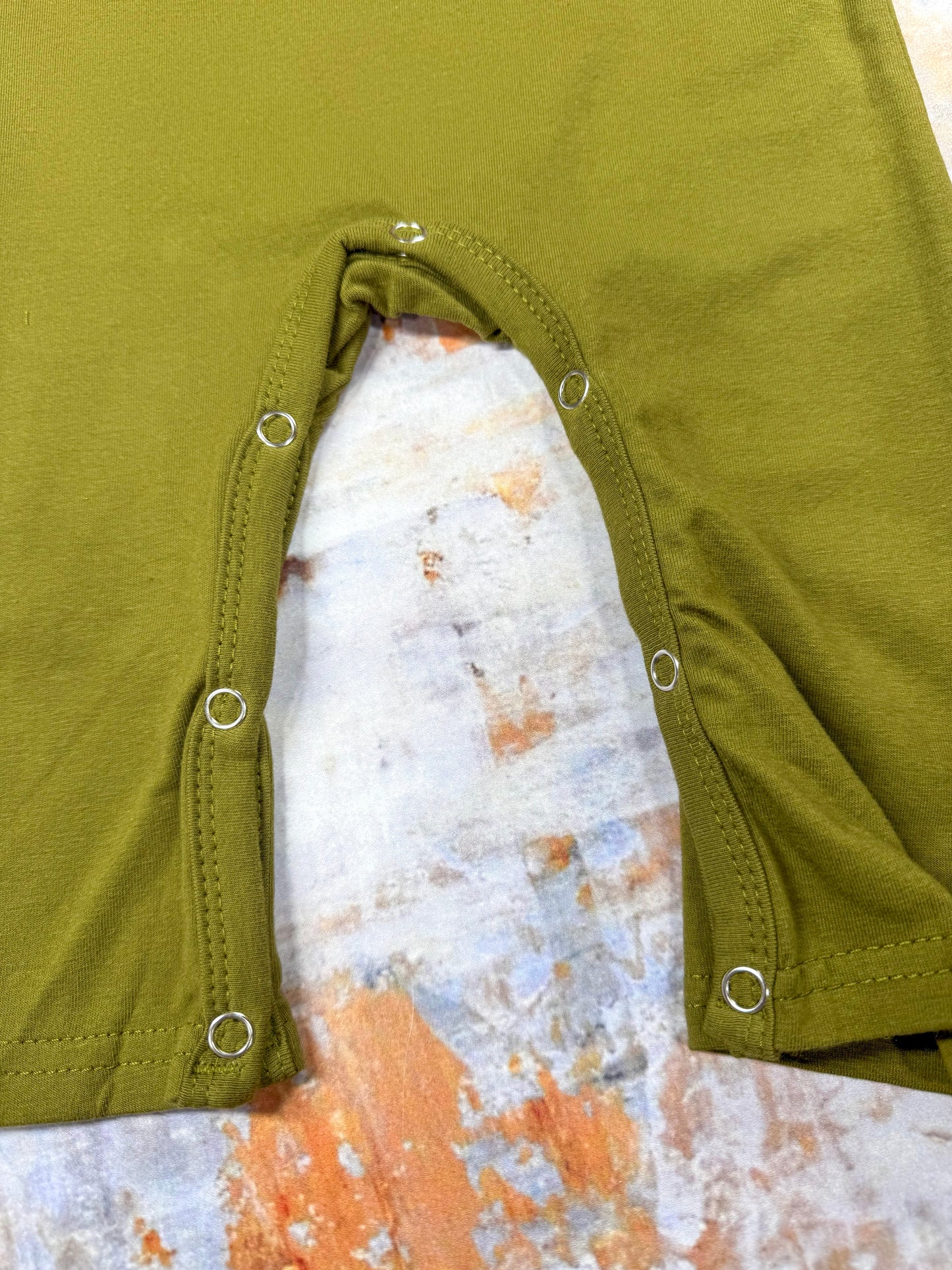 close up of the snaps on bottom of romper for easy changing
