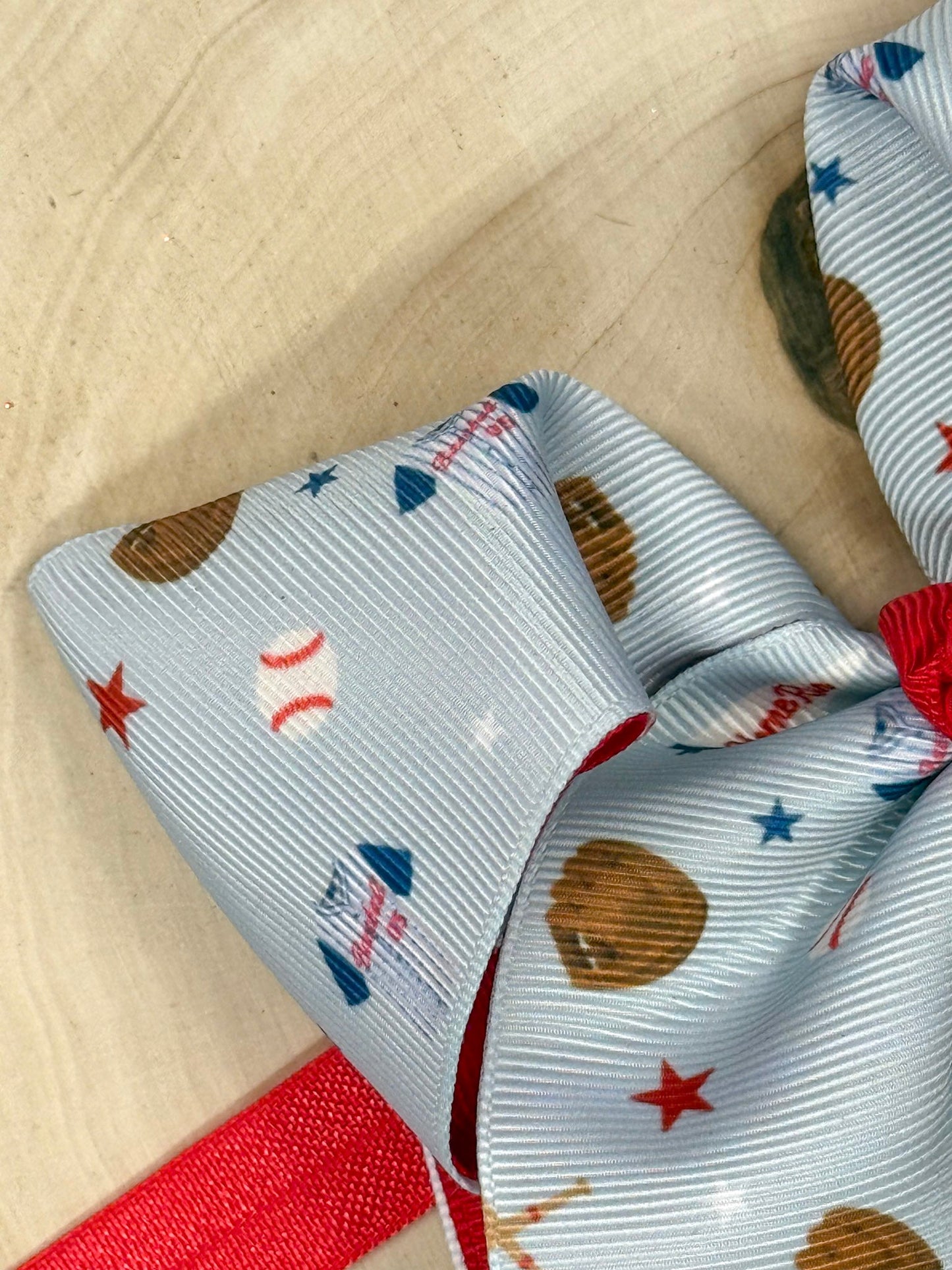 Close-up of a ribbon with baseball-themed pattern on a wooden surface