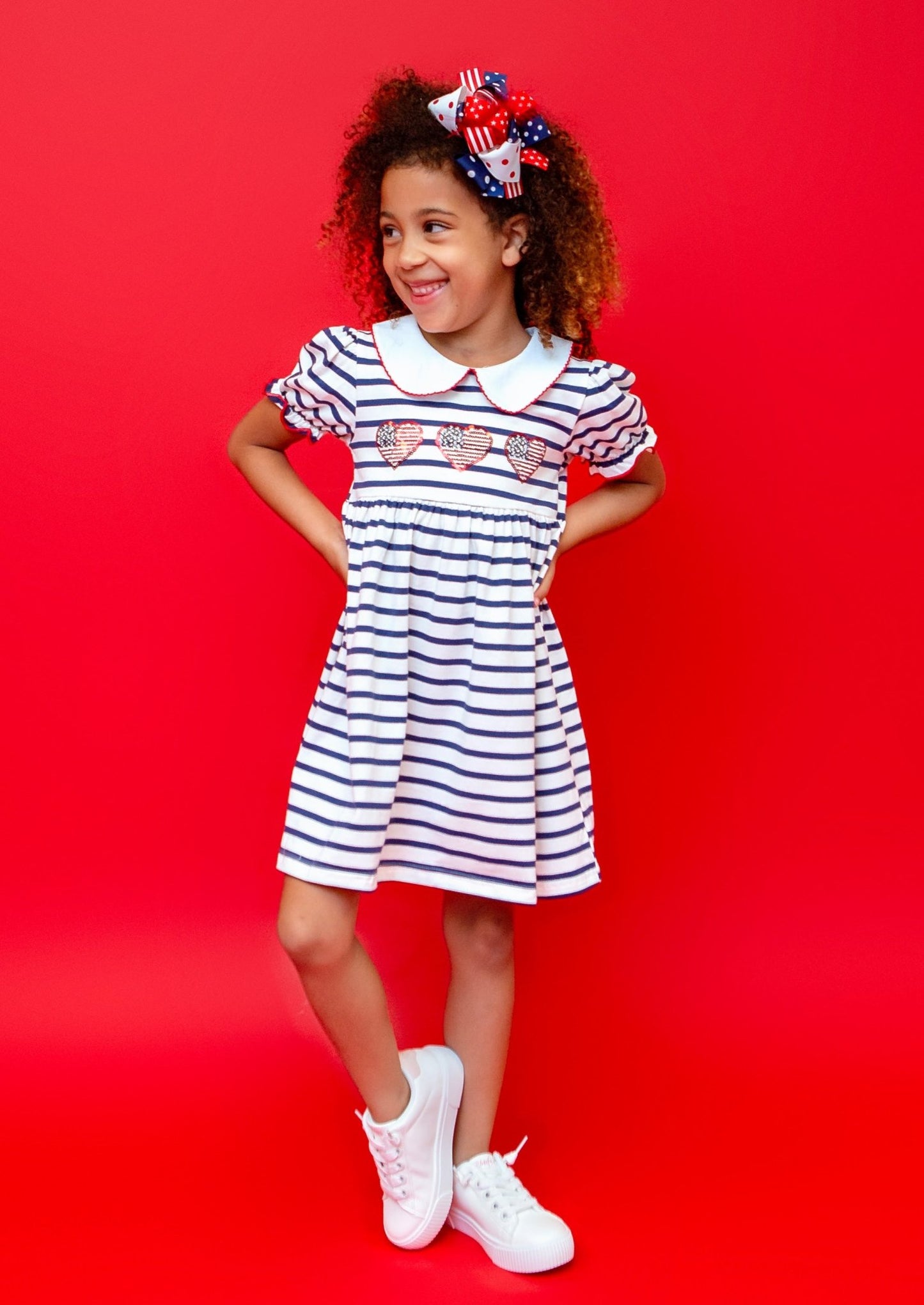 girl wearing a heart 4th of july striped dress