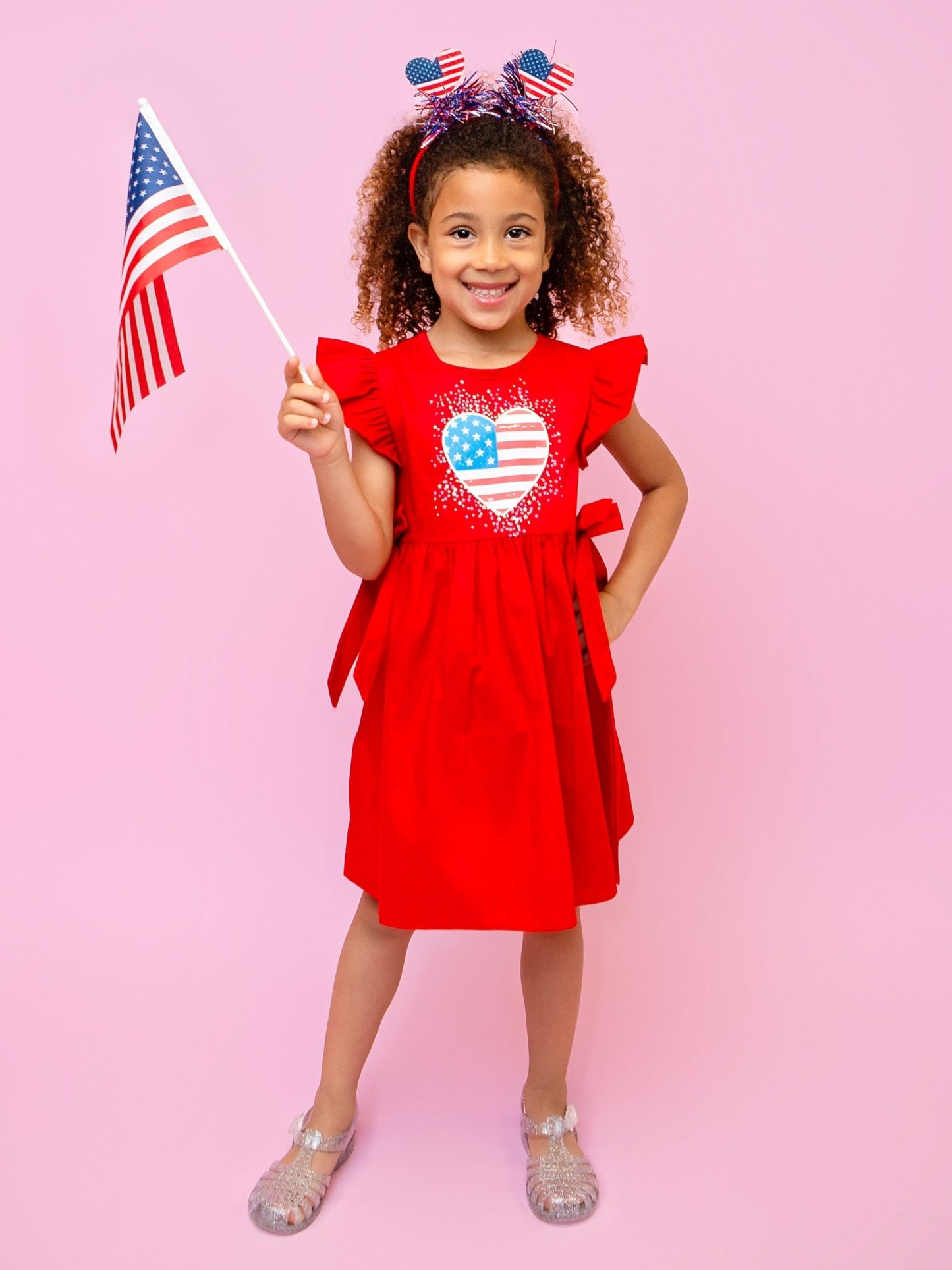 child wearing a red heart flag dress