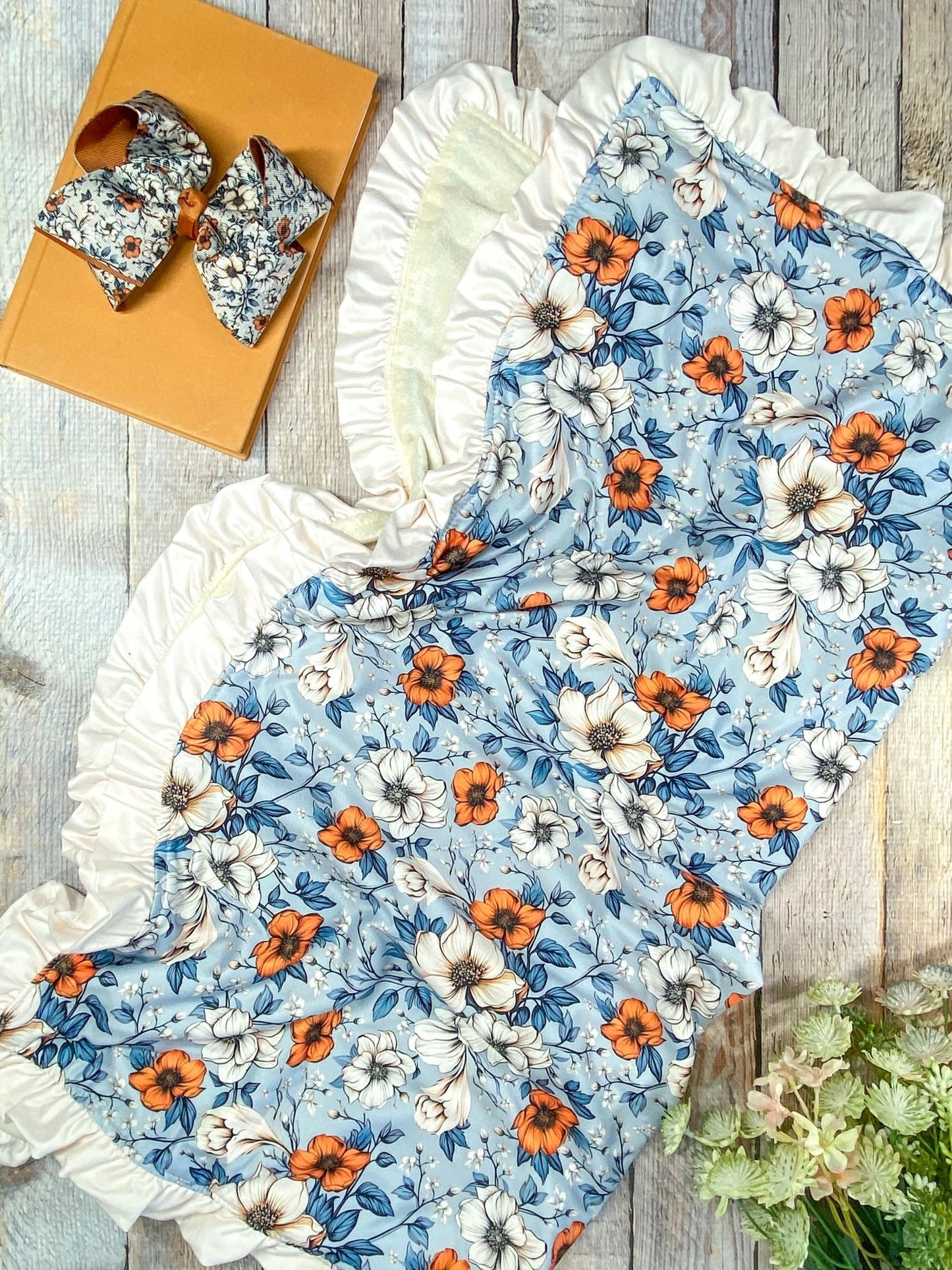 autumn blanket photo: Floral pattern with orange and white flowers on a wooden surface