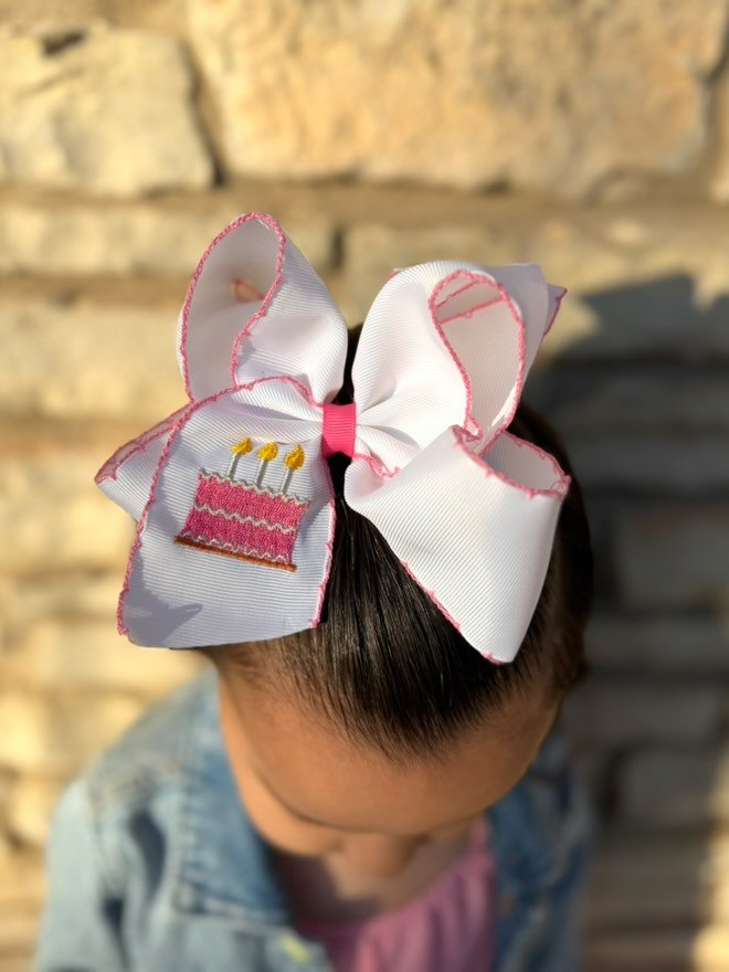 model wearing our Birthday Cake Embroidered Moonstitch Hair Bow