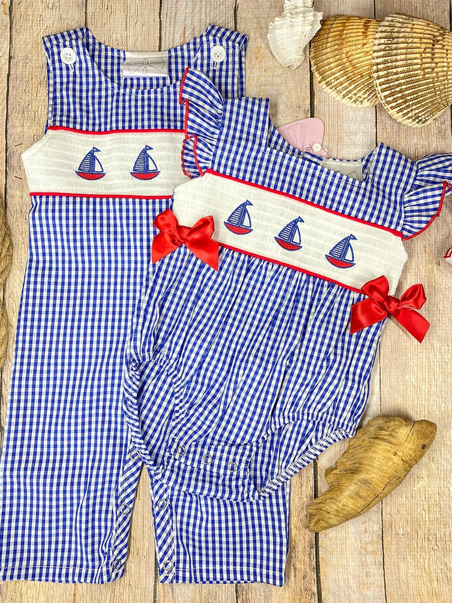 Blue checkered longall and baby romper with sailboat design on a wooden background