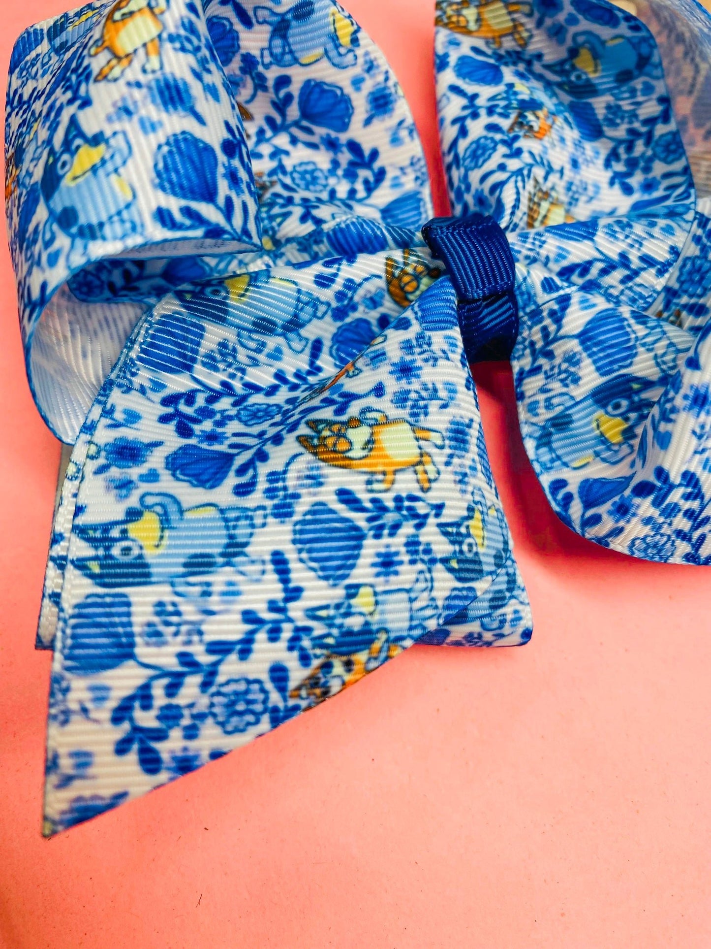 Blue floral-patterned ribbon on a pink background