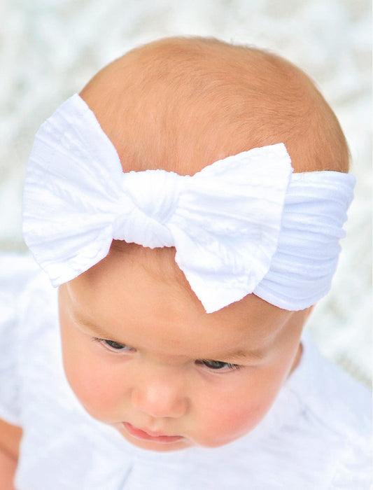 Girl wearing a white cable knit bow headband - Alternative view