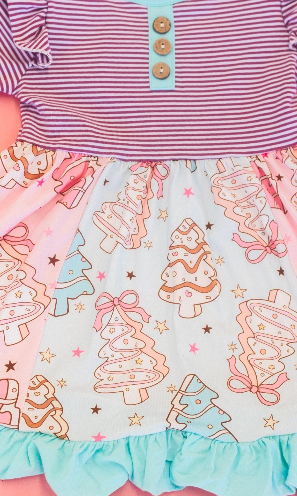 close up of tiered pattern of christmas tree cakes on skirt of the dress