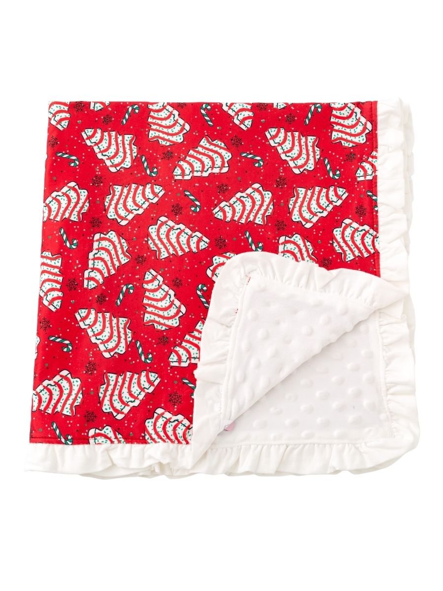 Christmas tree cake baby minky blanket with festive red holiday print, white dotted plush backing, and ruffle trim.