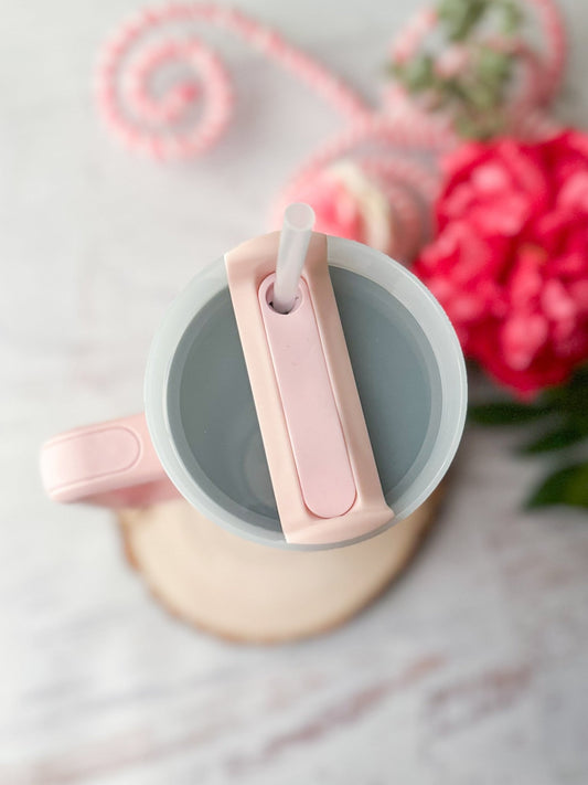 Pink mug with a spoon on a light background with flowers - Alternative view
