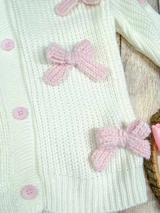 close up of the light pink knitted bows sewn onto sweater/cardigan - Alternative view