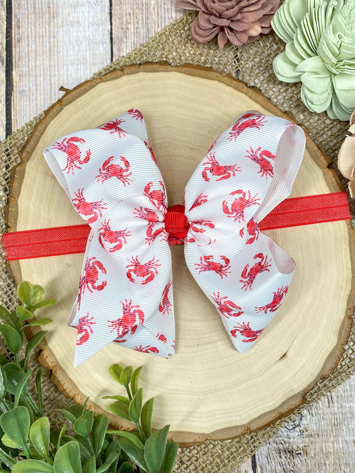 White headband with red patterns on a decorative plate with flowers in the background