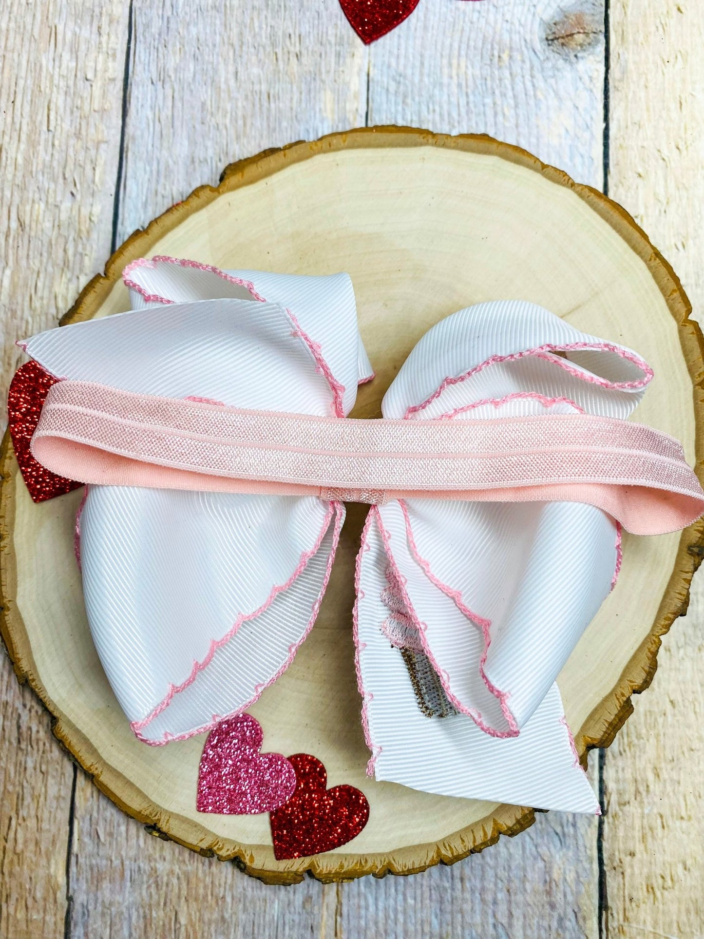 Decorative bows with pink and red accents on a wooden surface