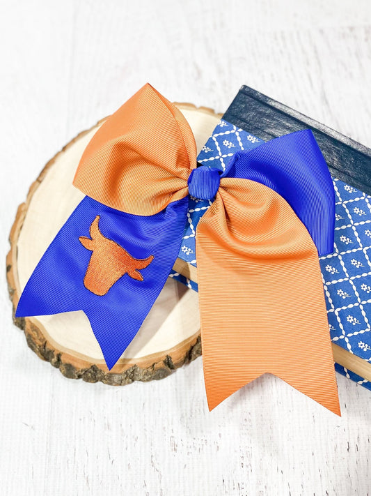 Orange and blue custom cheer bows with embroidered bull mascot on a wooden surface - Alternative view