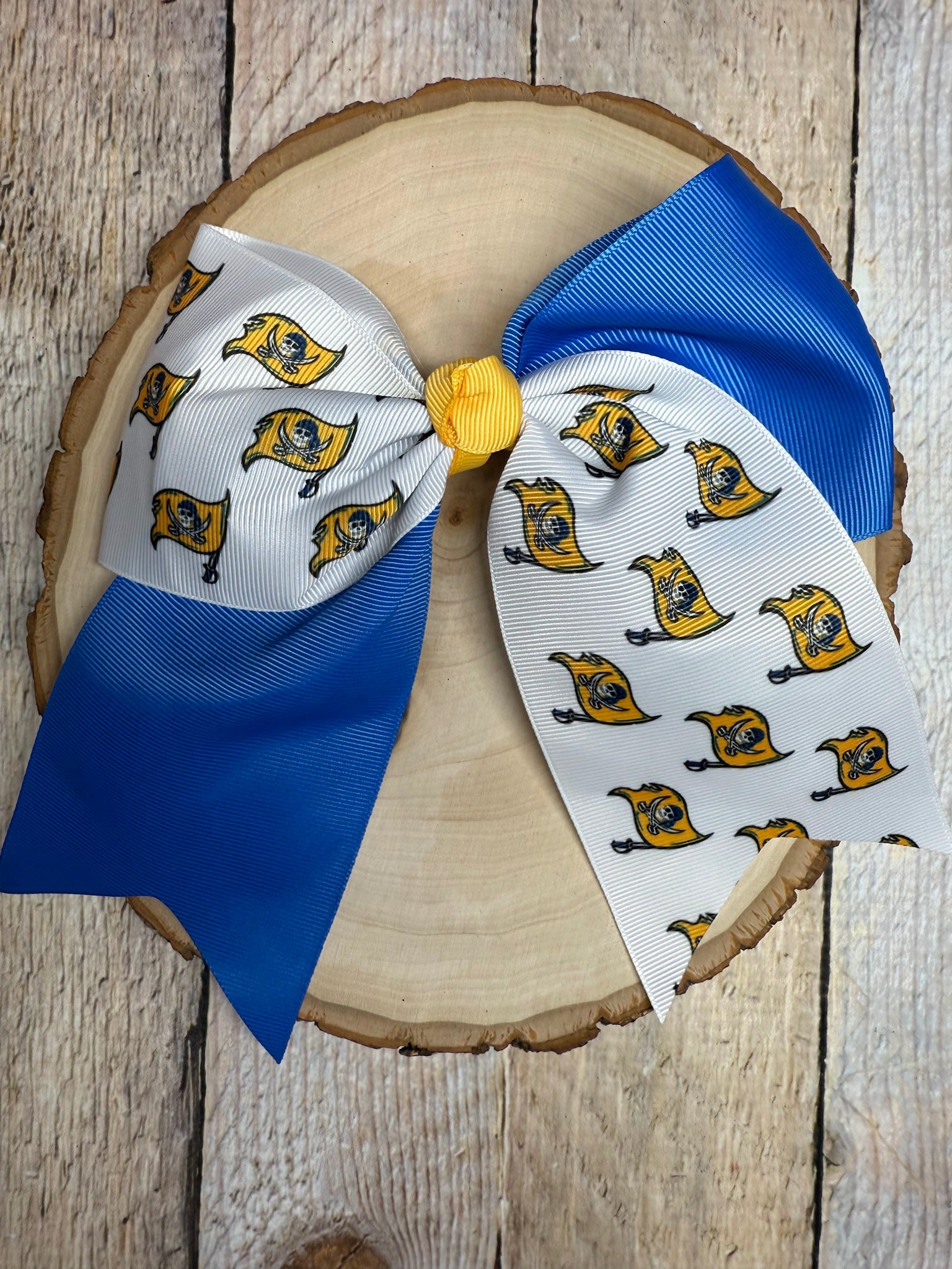 Large decorative bow with blue and white ribbons on a wooden surface