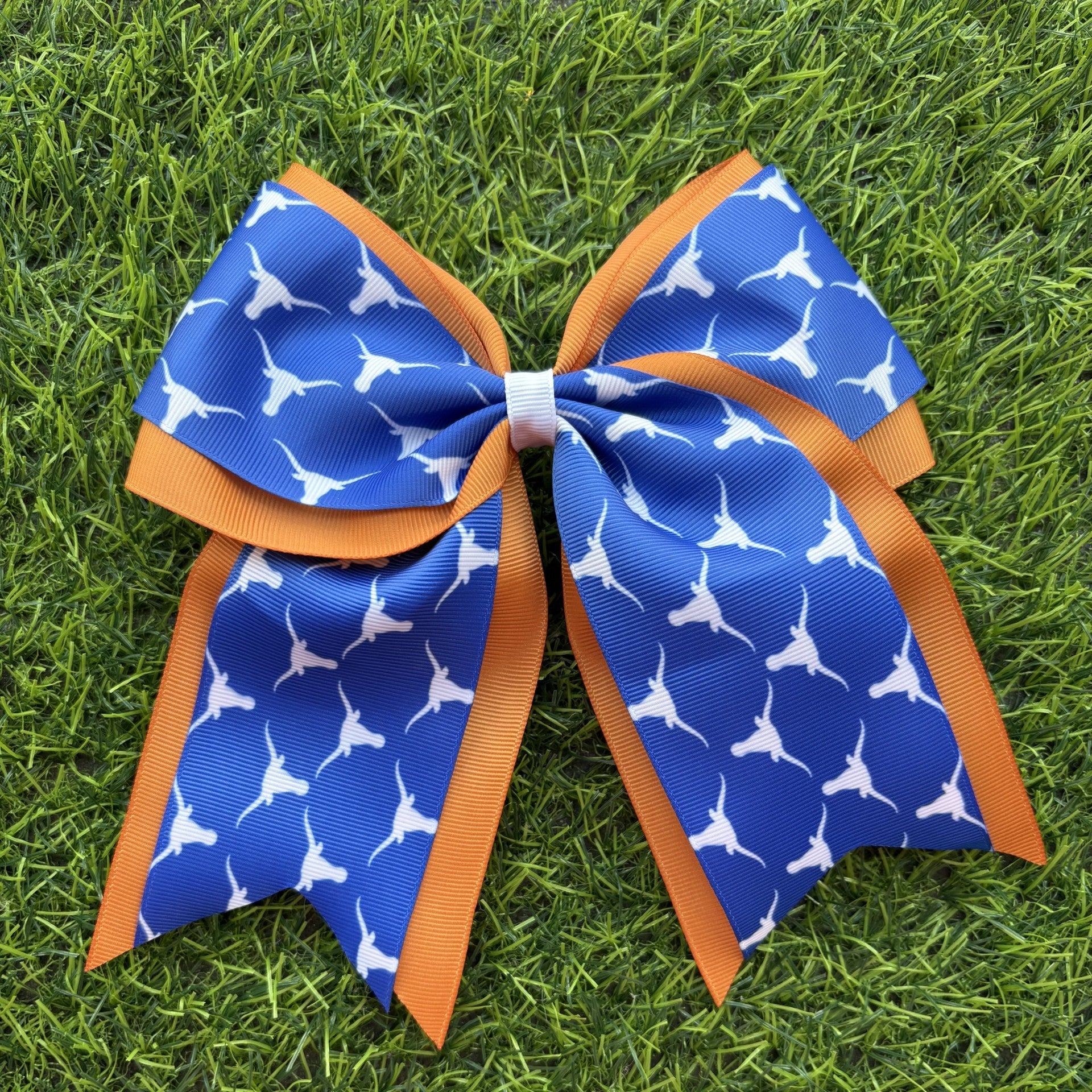 Blue and orange bow with white patterns on a grass background
