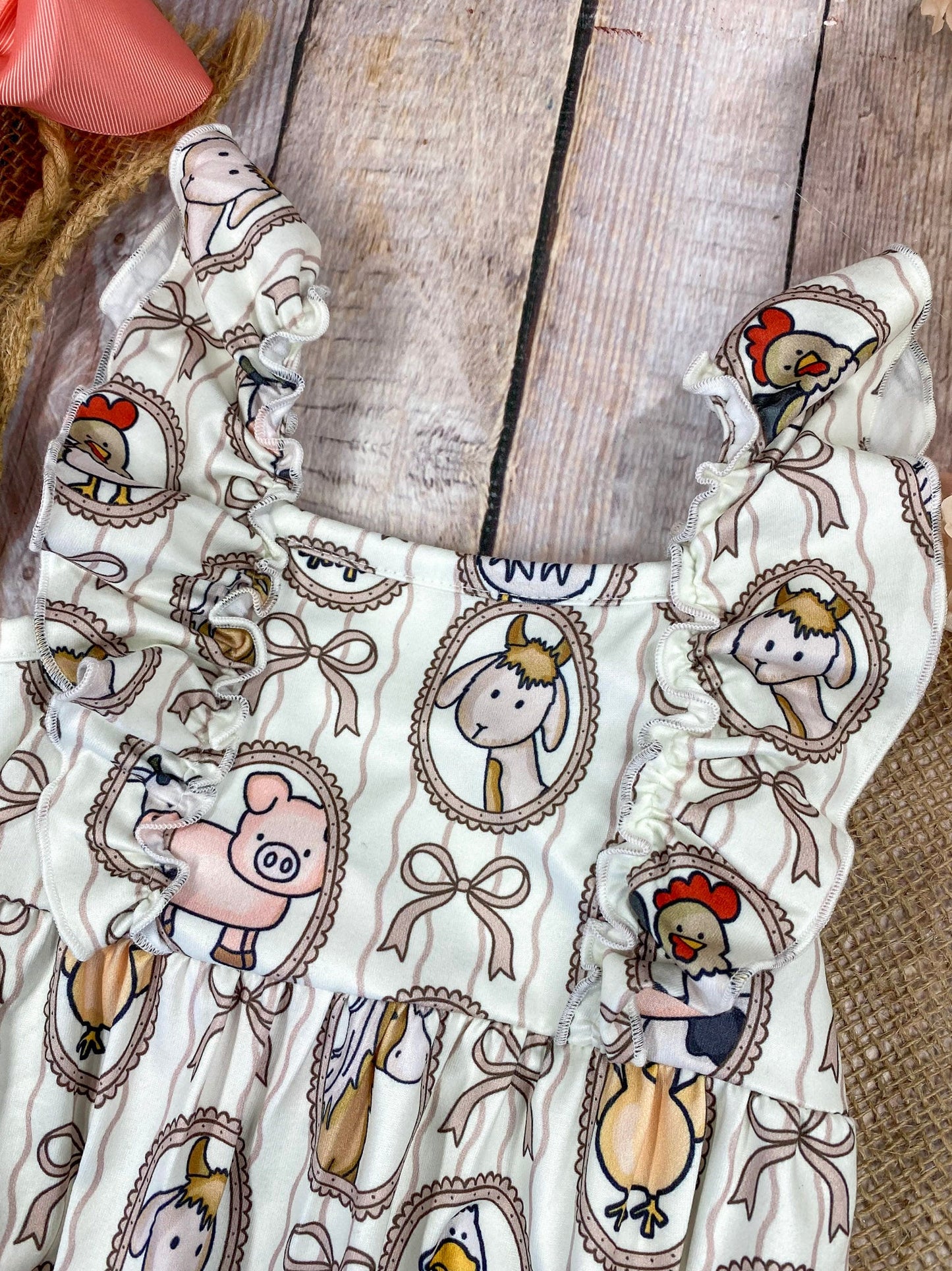 Farm animal baby boutique romper on wooden background