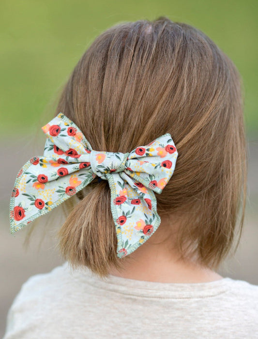 Girl wearing a floral hand tied hair bow - Alternative view