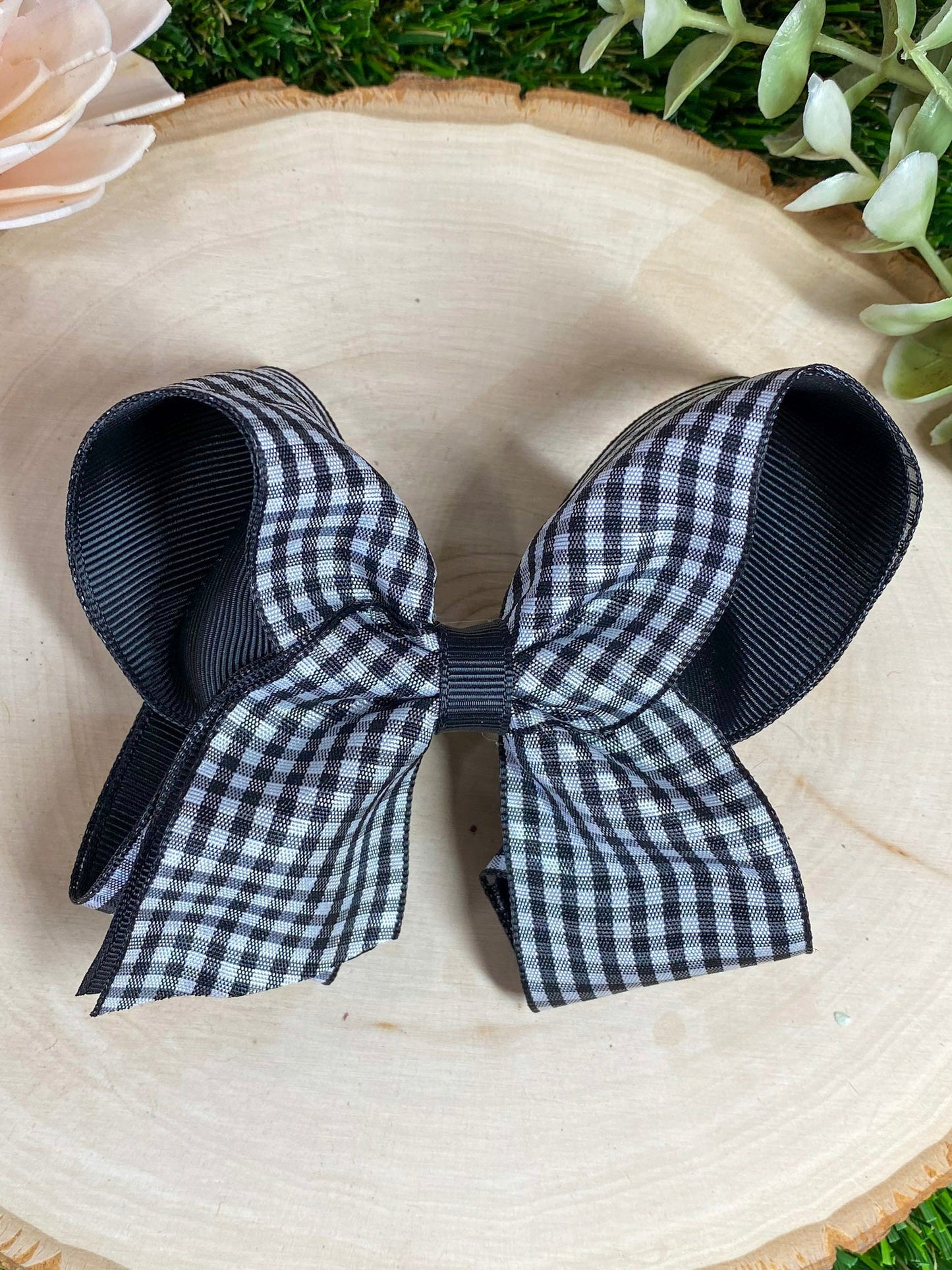 black and white gingham bow on a wooden surface