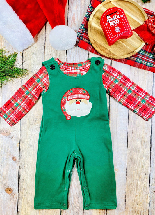 Infant boys’ green Christmas overalls with red plaid long sleeve shirt and Santa face applique on the chest.