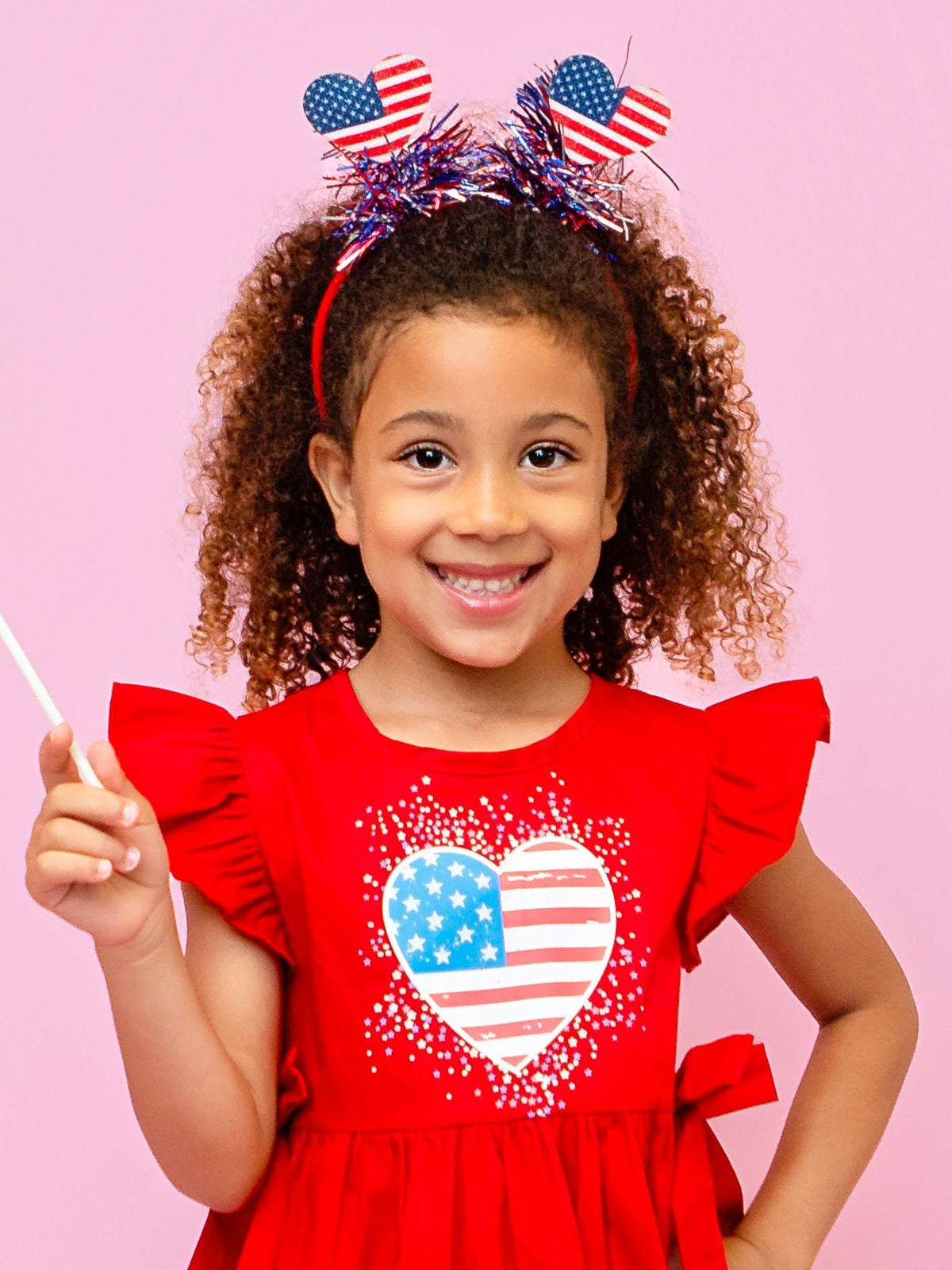 Girl wearing a red, white and blue heart sparkler headband