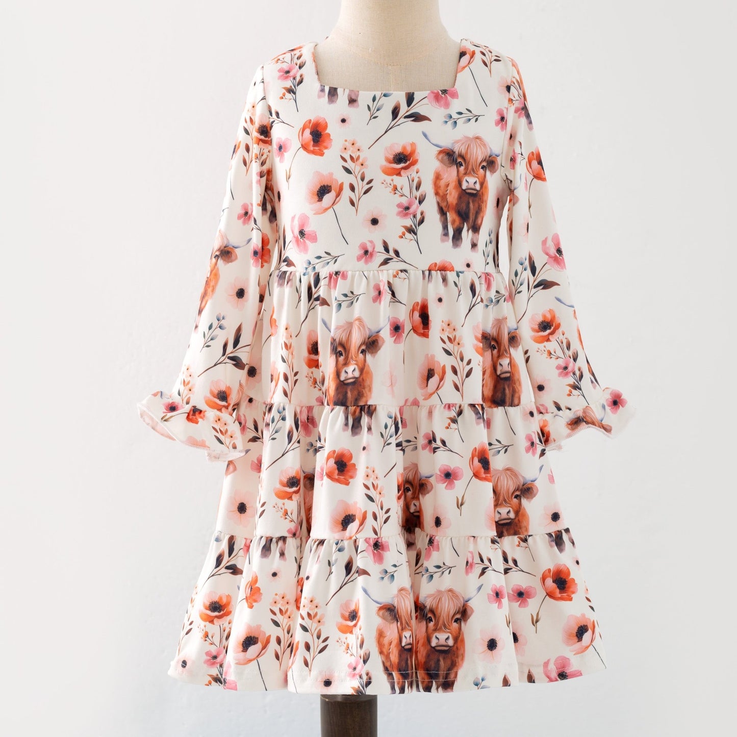 Dress with floral and cow print on a mannequin against a white background