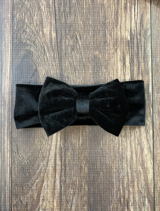 Black bow headband on a wooden surface - Alternative view