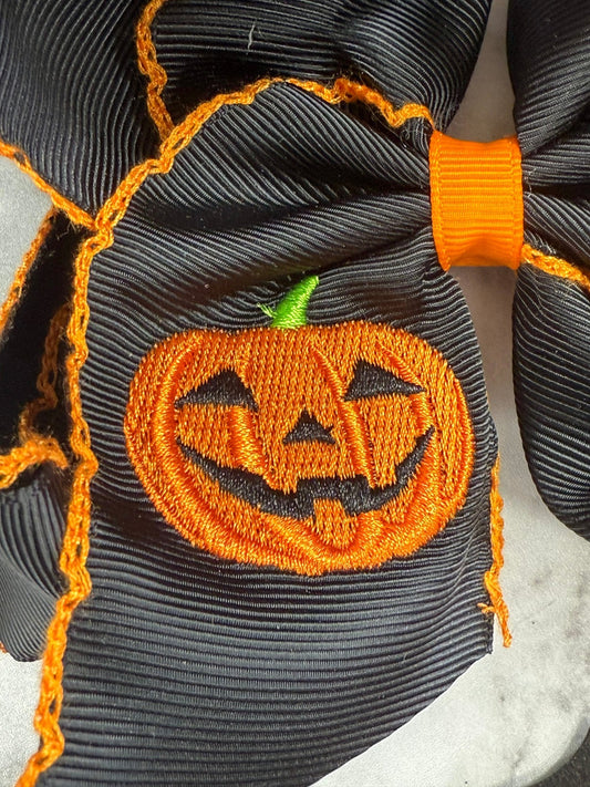 Close-up of jack-o-lantern embroidery and moonstitch detail on hair bow - Alternative view