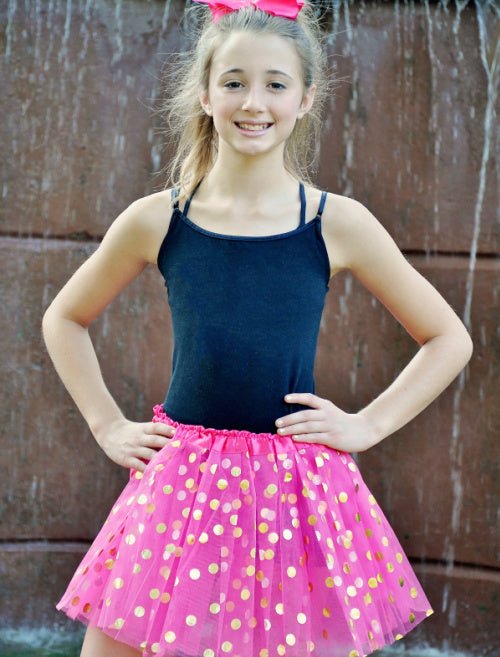 model wearing hot pink and gold dot tutu standing outside
