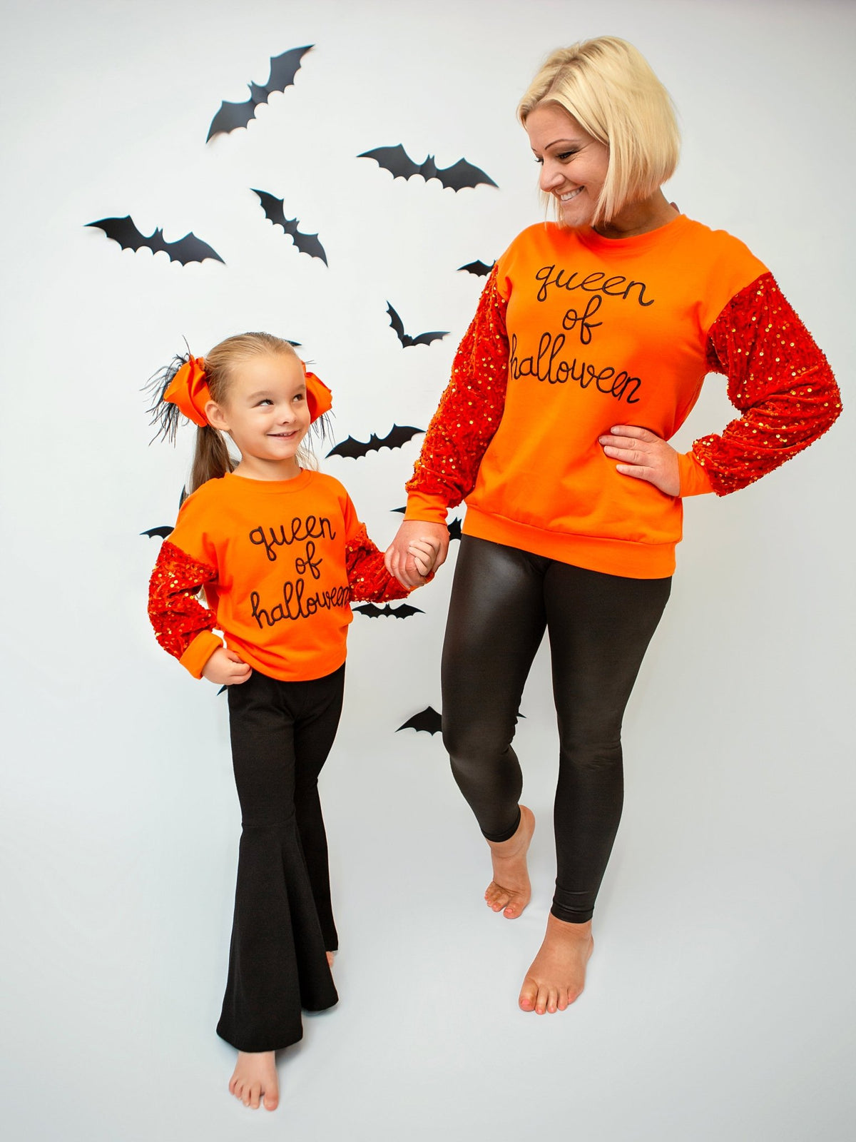 Mom and daughter wearing Queen of Halloween sweaters