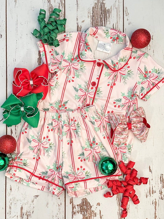 Children's pajama set with red and green bows and ornaments on a wooden surface - Alternative view