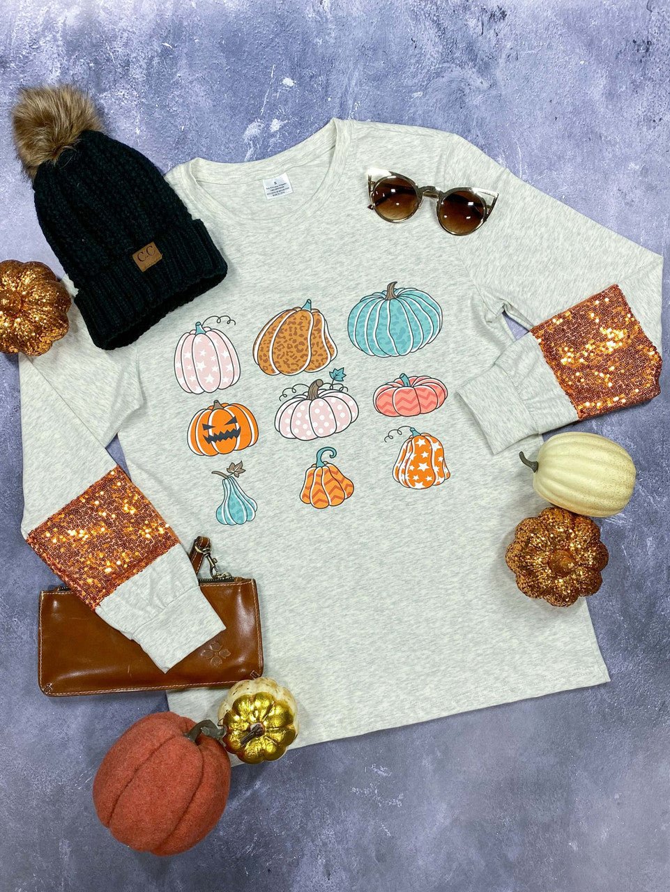 Gray pumpkin print shirt laid flat with a black beanie