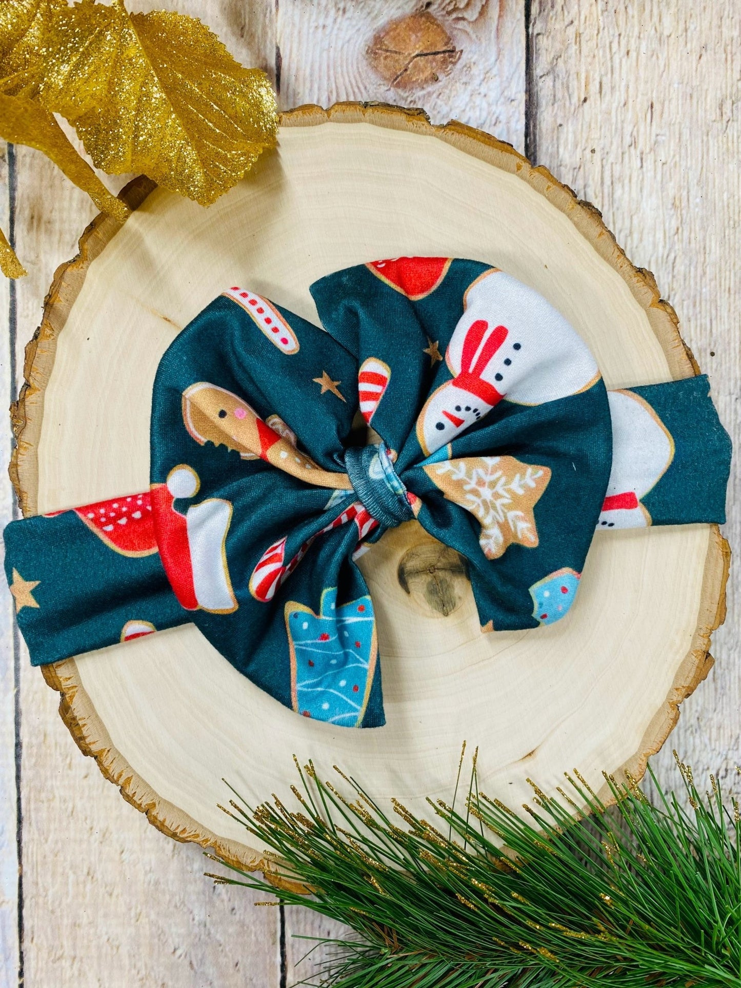 Christmas-themed hair bow on a wooden surface with decorative elements