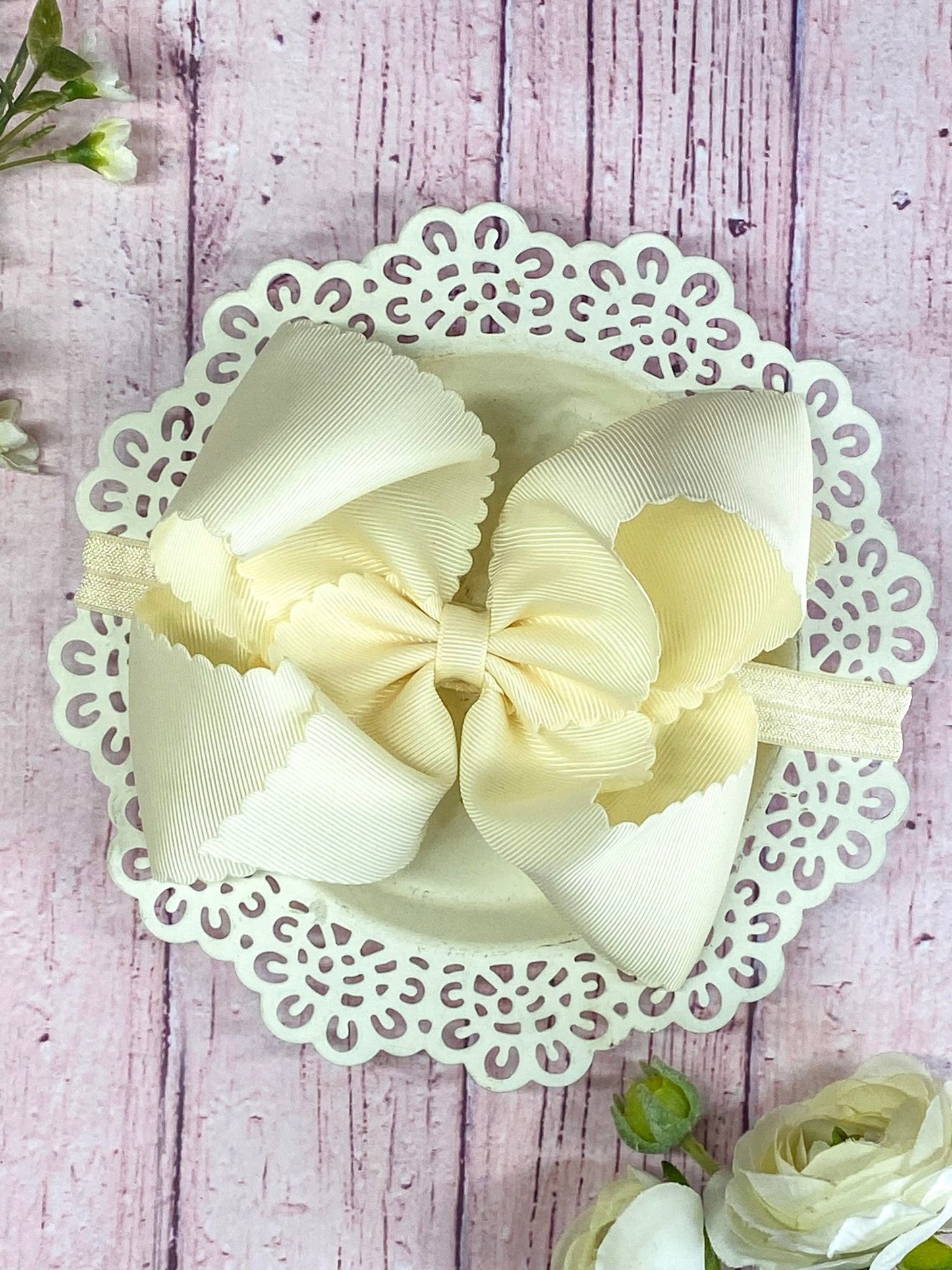 lvory hair bow on headband on wooden display
