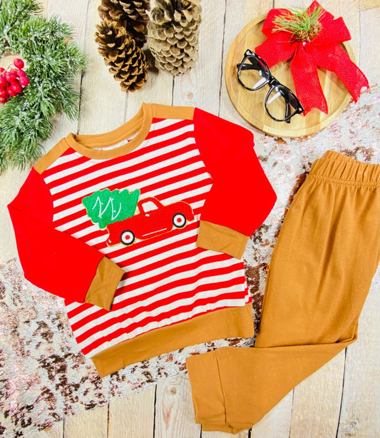Boys’ two-piece Christmas outfit with red-and-white striped long sleeve top featuring a red truck and Christmas tree, paired with brown pants.