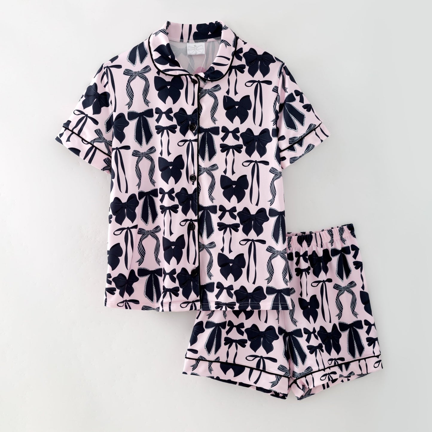 Pink pajama set with black bow pattern on a white background