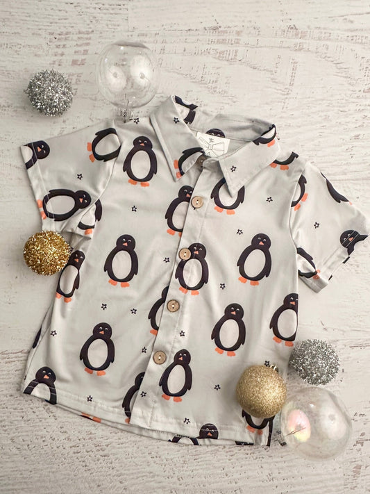 Children's pajama set with penguin pattern on a light wooden surface with decorative ornaments. - Alternative view