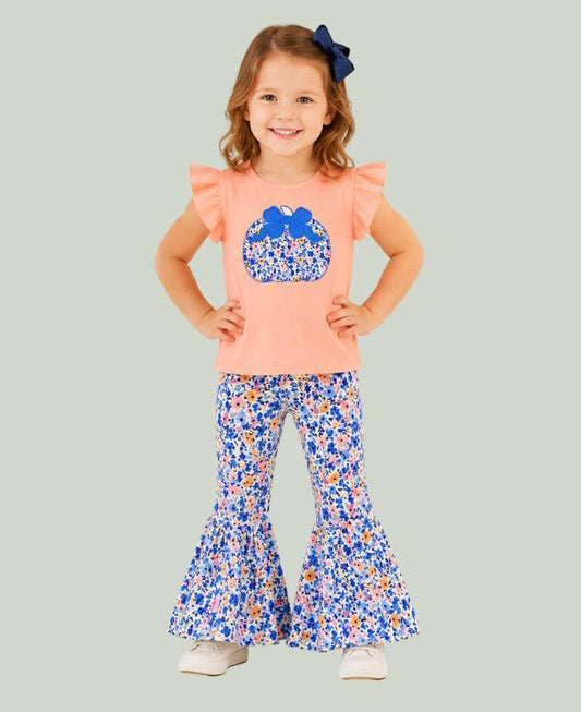 model wearing pumpkin outfit on light blue backdrop - Alternative view