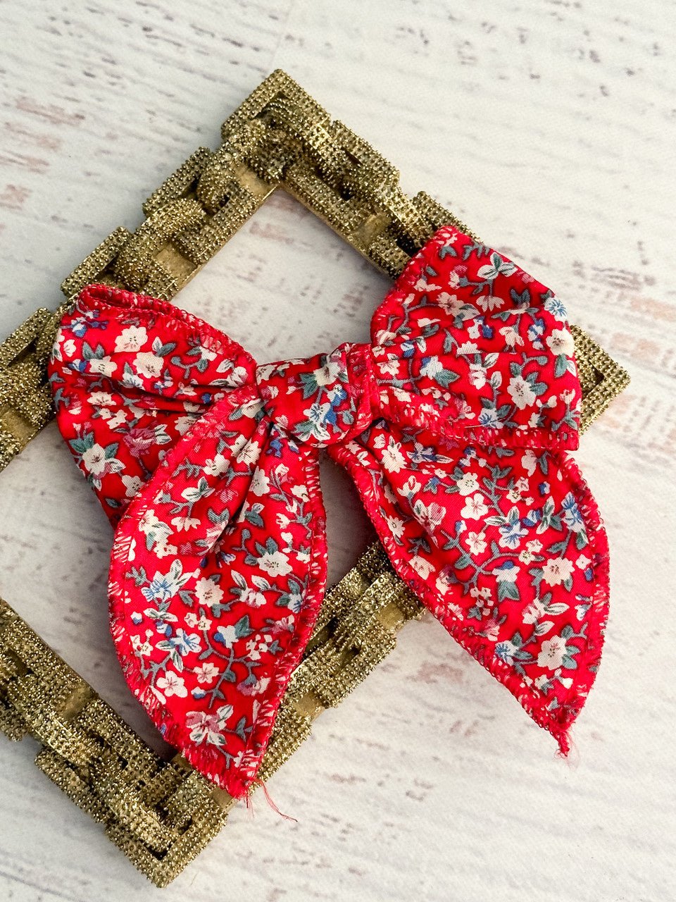Red floral print bow with a removable single alligator clip. Measures approximately 5x5 inches.