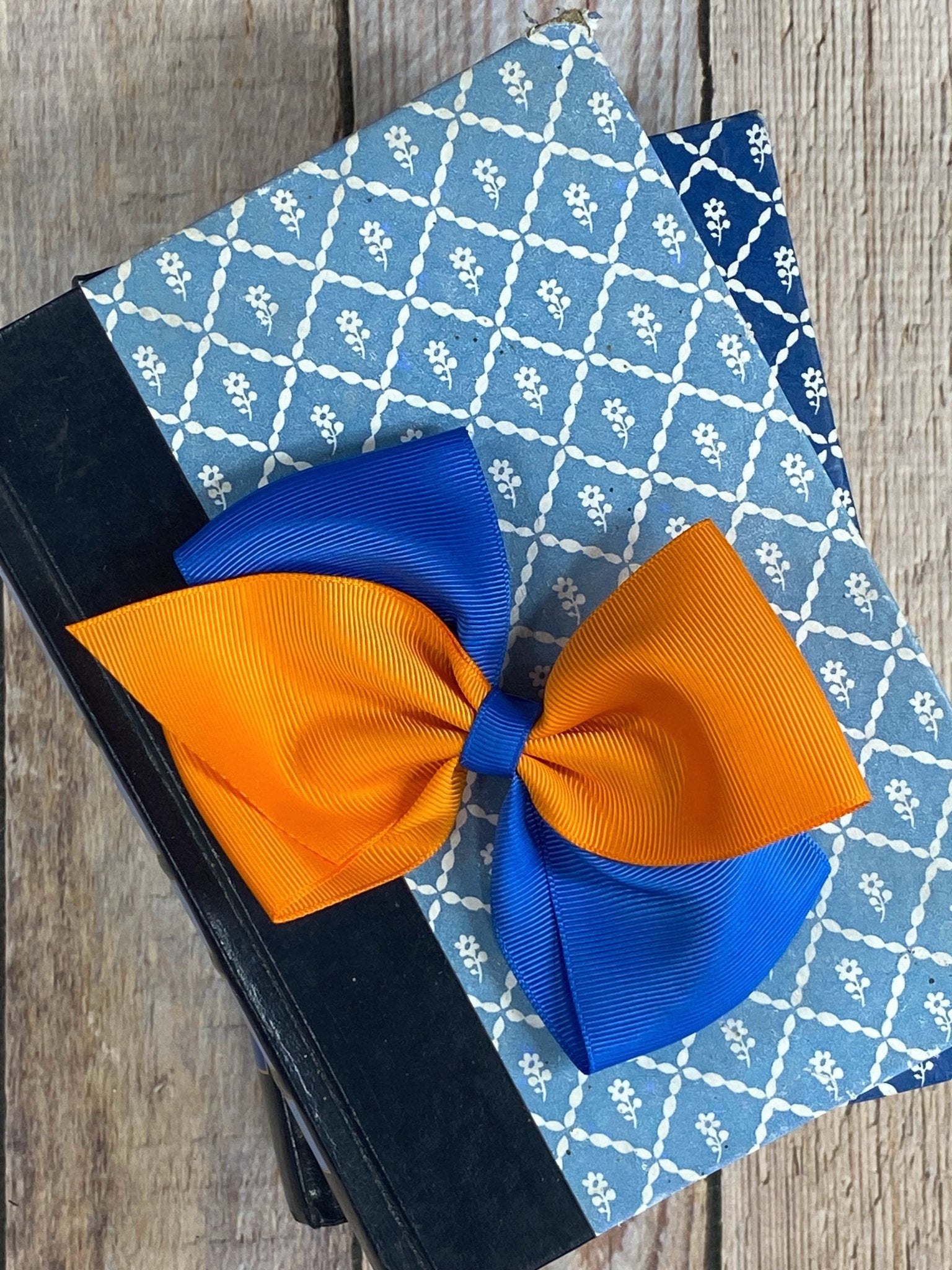 Blue and orange hair bow on a wooden surface