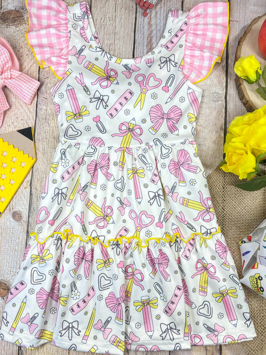 Children's dress with stationery-themed print on a wooden background - Alternative view