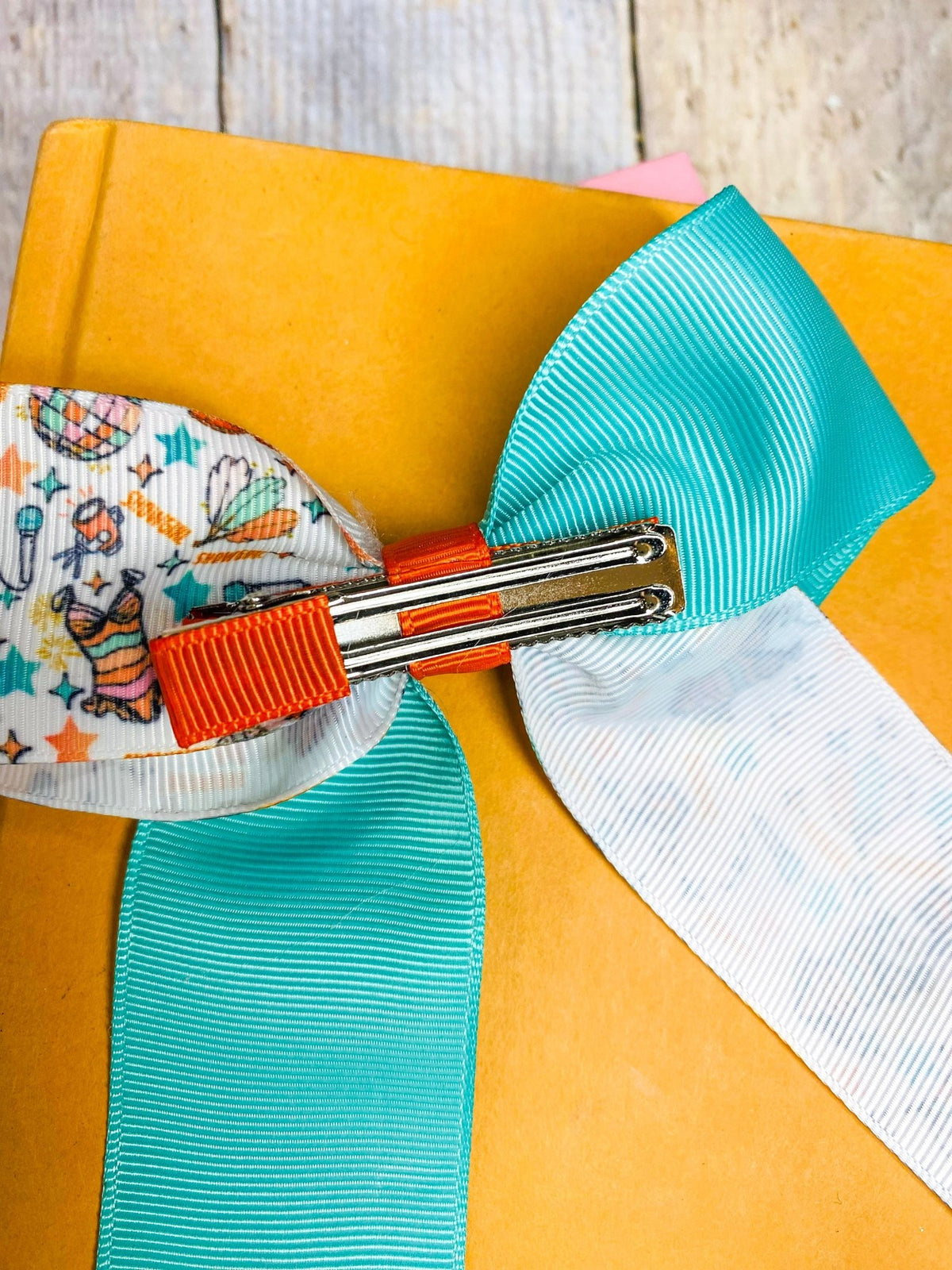 Showgirl Era long ribbon hair bow with alligator clip on a yellow background