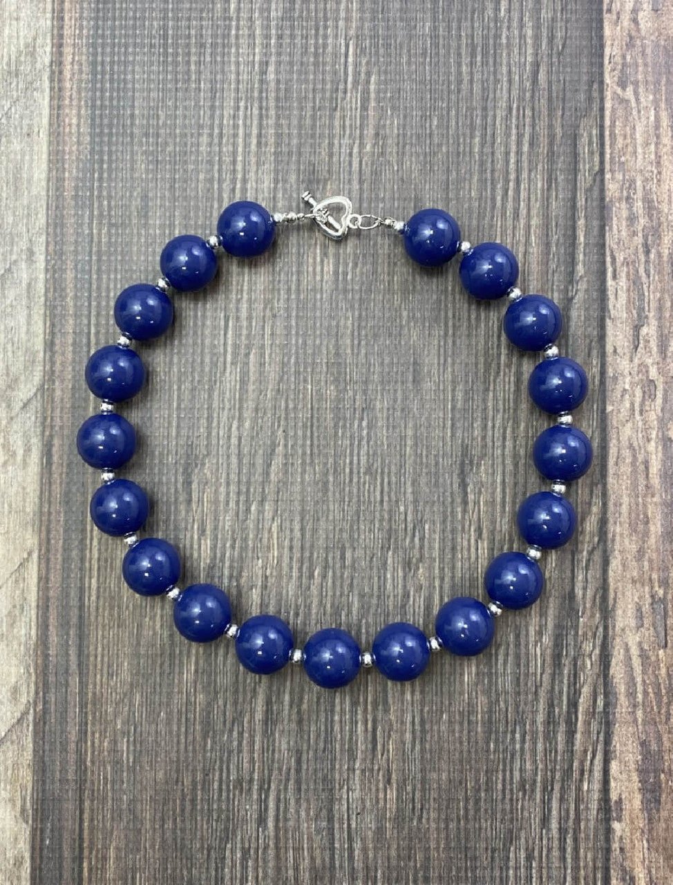 Navy chunky bead necklace on a wood table